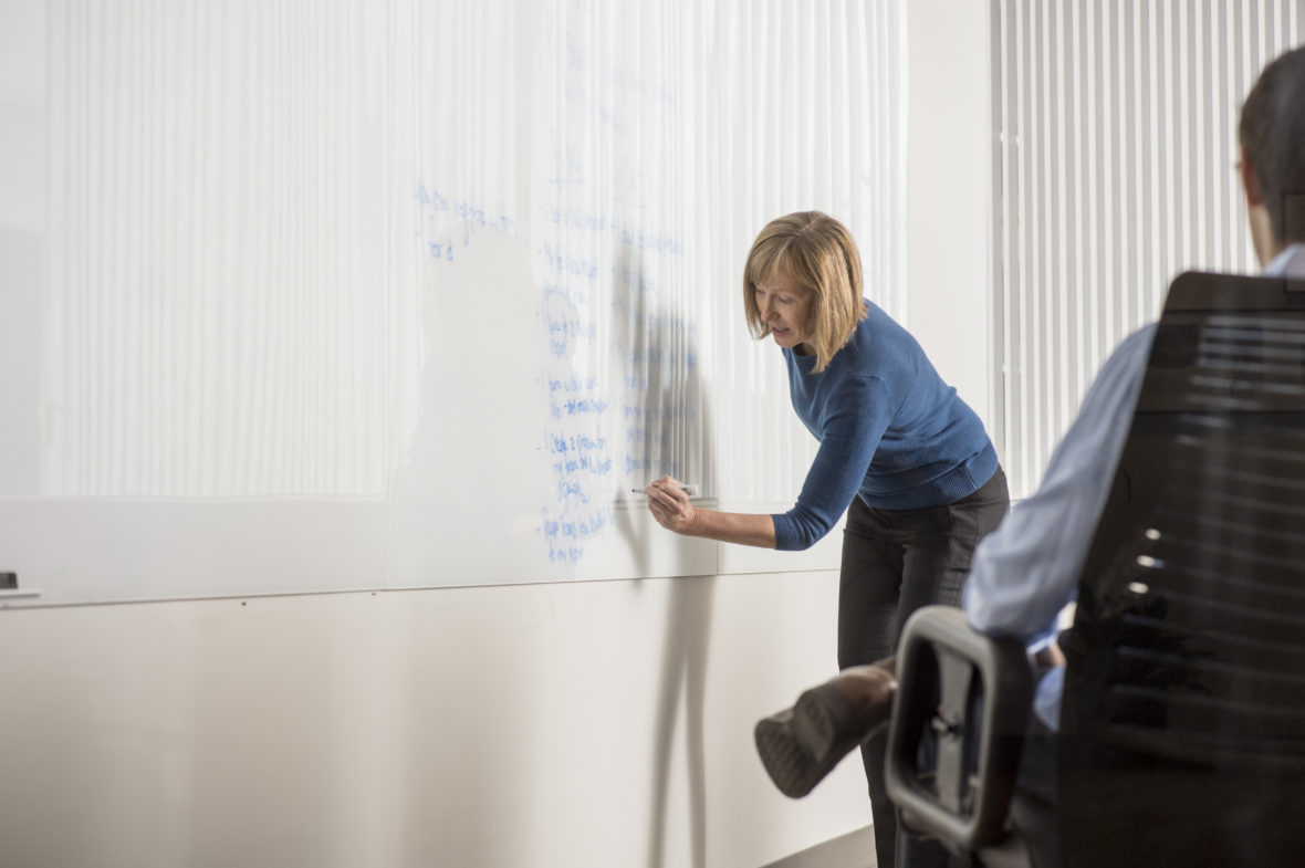 Woman white boarding negotiation tactics for colleagues. 